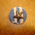 Metal button with ocean star.
