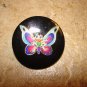 Large plastic button with colorful butterfly.