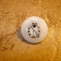 Mother of pearl button with rifle and eagle.