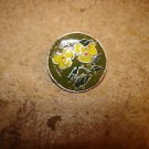 Signed silver metal button with yellow flower.