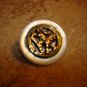 Old mother of pearl button with brass lion inlay.