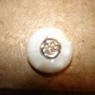 Carved mother of pearl button with smiling sun.