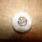 Carved mother of pearl button with smiling sun.