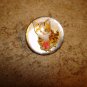 Mother of pearl button with orange cat holding a fish.