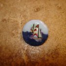 Nicely painted button with sailboat.