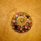 Antique brass button with colorful rhinestones.