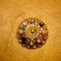 Antique brass button with colorful rhinestones.