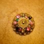 Antique brass button with colorful rhinestones.