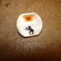 Mother of pearl button with red sun and figure.