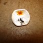 Mother of pearl button with red sun and figure.
