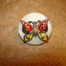 Mother of pearl button with metal butterfly.