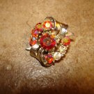 Silver metal button with aurora borealis like rhinestones.
