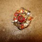 Silver metal button with aurora borealis like rhinestones.