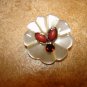 Carved plastic button with tier shape corals and garnet color stone.