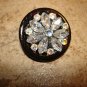 Hard plastic button with tier shape glass beads and rhinestones.
