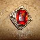 Silver metal button with large garnet color stone.