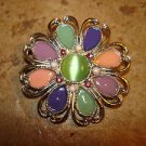 Large silver metal button in shape of flower with jade color stone.