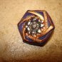 Dark blue and gold plastic button with sunflower.