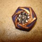 Dark blue and gold plastic button with sunflower.