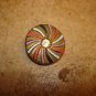 Metal button with pin wheel patern and rhinestone.