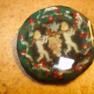 Paper mache button with cherubs signed by artist. Paper mache button with cherubs signed by artist.