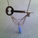 Antique Sideways Skeleton Key Necklace: Light blue bead dangling from neck of the key.