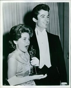 Patty Duke holding her Oscar prize statue and George Chakiris standing beside he