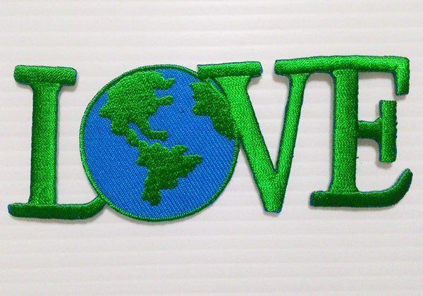 Embroidered green love earth iron-on patch.