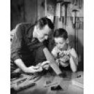 Close-up of a mature man with his son making a model of an airplane Canvas Art -  (24 x 36)