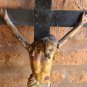 Antique old Jesus Christ on wooden cross. polychrome paper mache. breaks