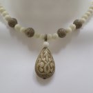 Necklace White Glass Beads with a Carved Nut Pendant