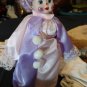 Girl clown, purple, and pink coloring. Curly purple hair with hat.