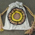 Upcycled and Reconstructed Jean Drawstring Bag With a Bright Crocheted pocket front.