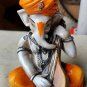 Karigaari India Karigaari Polyresine Ganesha Playing Instrument Orange Figurine