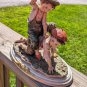 Vintage Girl Ridding Boy Signed Ceramic Figurine
