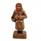 Vintage carved wood figurine of a woman knitting while standing