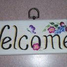 welcome sign with small burgundy & purple flowers