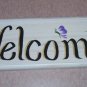 welcome sign with blue & small orange flowers