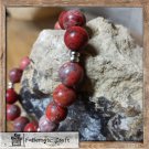 Handmade jewelry.A bracelet made of red jasper with metallic silver beads.The unisex bracelet.
