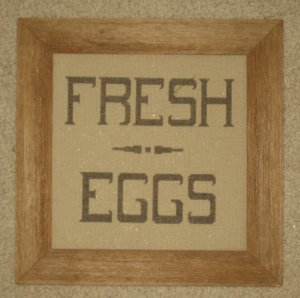Framed stitched piece in barnboard frame