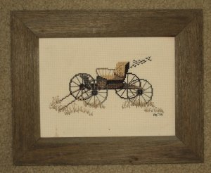 Framed cross stitched piece in barnboard frame