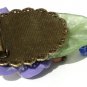 Bronze brooch including a large flower on a lucite leaf all adorned with four glass beads: "Exotic"