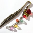 Bronze feather bookmark with frosted multicolored pearls, a red heart and a brown leaf