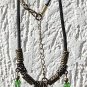 Necklace with three embossed green glass beads and three glass drops on a rubber cord: "Mystery"