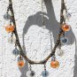 Bronze necklace with twelve crystal nugget beads of three different colors on a rubber cord: "Maya"