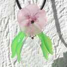 Pendant necklace with a large crystal drop adorned with a flower and lucite leaves: "Drop of light"