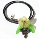 Pendant necklace with a snake adorned with a flower and leaves on a rubber cord:"Temptation"