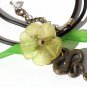 Pendant necklace with a snake adorned with a flower and leaves on a rubber cord:"Temptation"