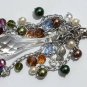 Bag charm with a big transparent central drop and various multicolored glass beads and charms