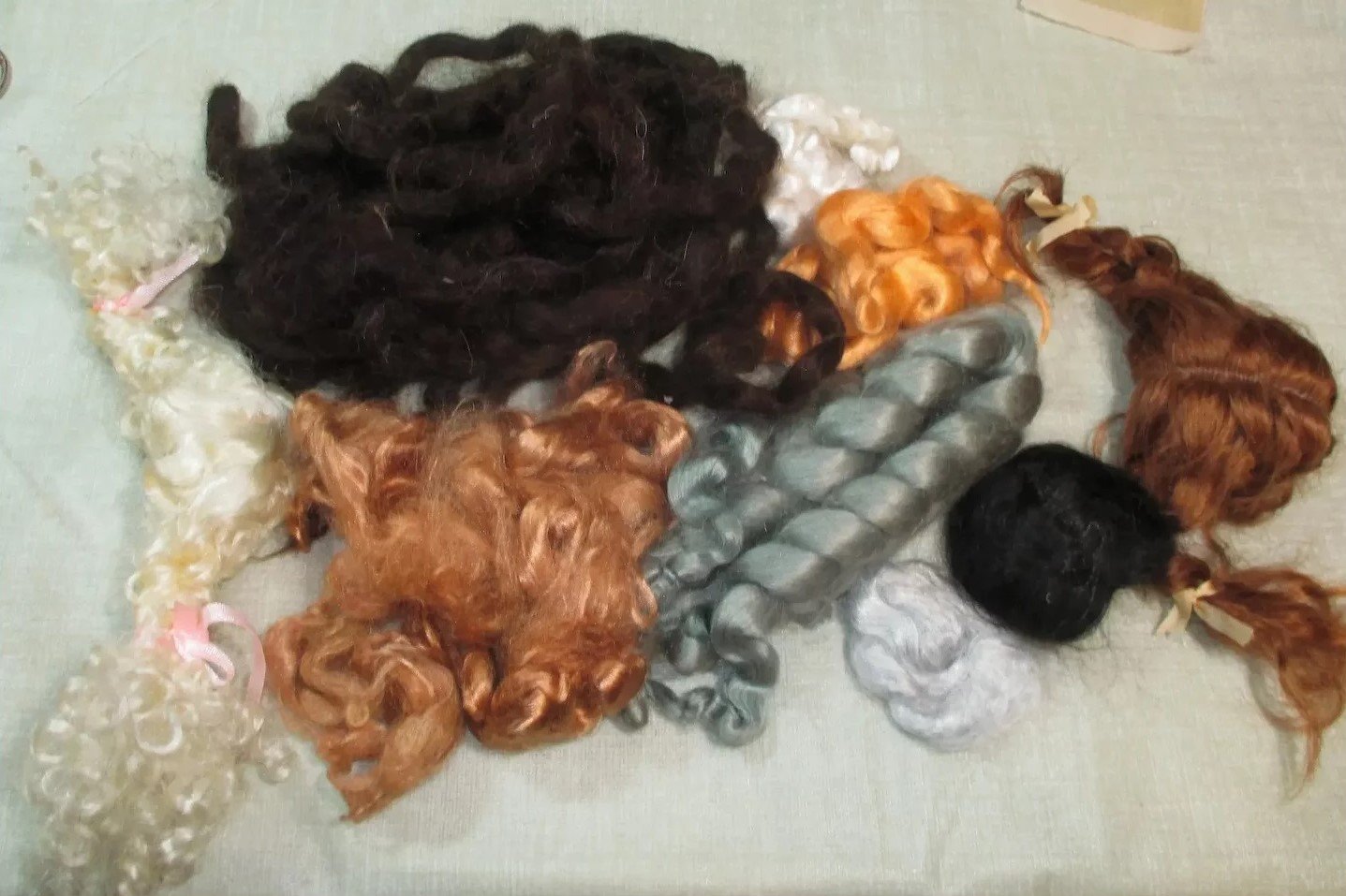 Three large doll wigs (6½"10") and assorted mohair for doll hair/wig